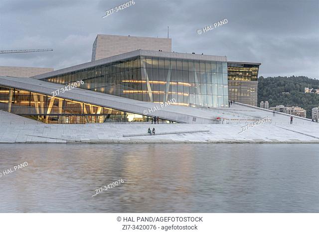 OSLO, NORWAY - July 21 2019: glass transparency at Opera theater with people on its flat roof, shot under dusk cloudy bright summer light on july 21
