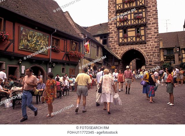 France, Alsace, Riquerwihr, Haut-Rhin, Europe, wine region, outdoor cafT, People walking on the cobbled streets in the picturesque village of Riquerwihr in the...