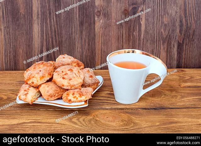 A cup of tea and a plate with homemade cookies on a wooden table