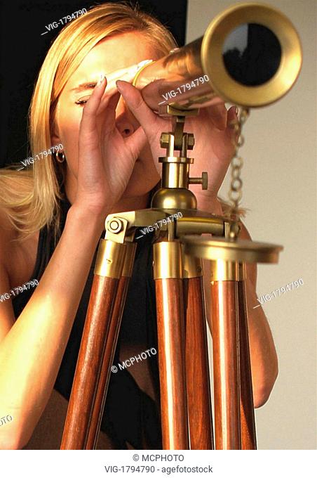 A blond woman looking through telescope - 01/01/2009