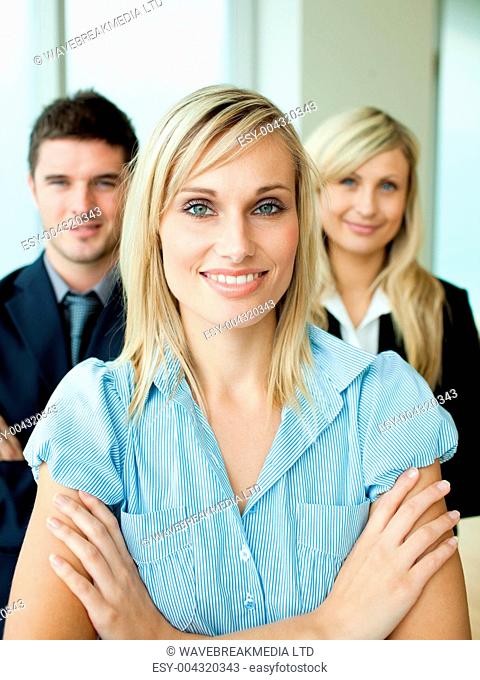 Business people headed by a woman with folded arms