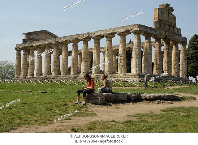 Two girls in front of Temple of Ceres in Paestum, Italy, Europe