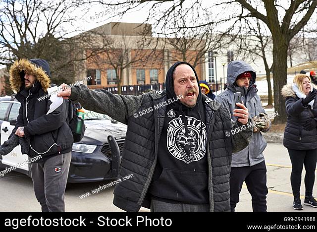 A man argues to police to allow him to cross a police line in order to walk his dog on 12 February 2022 in Windsor, Ontario on day six of the Freddom Convoy...
