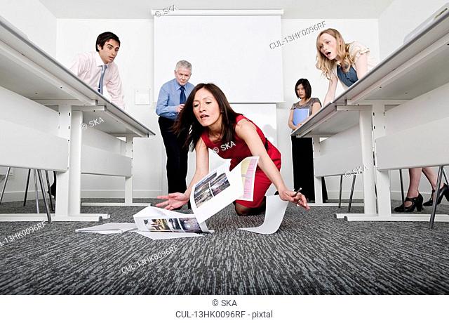 woman falling scattering documents
