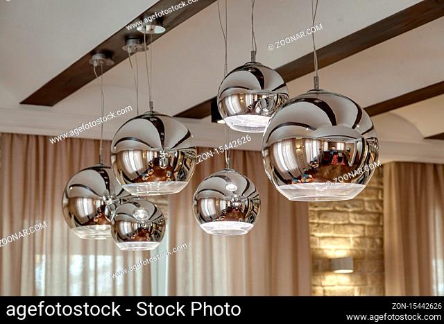 Modern chrome lamp on the ceiling in the room