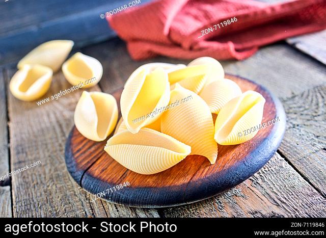 raw pasta on the wooden board and on a table