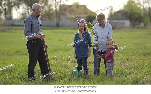 Multi generation family planting tree outdoor
