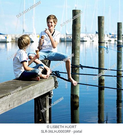 Boys eating ice cream on pier