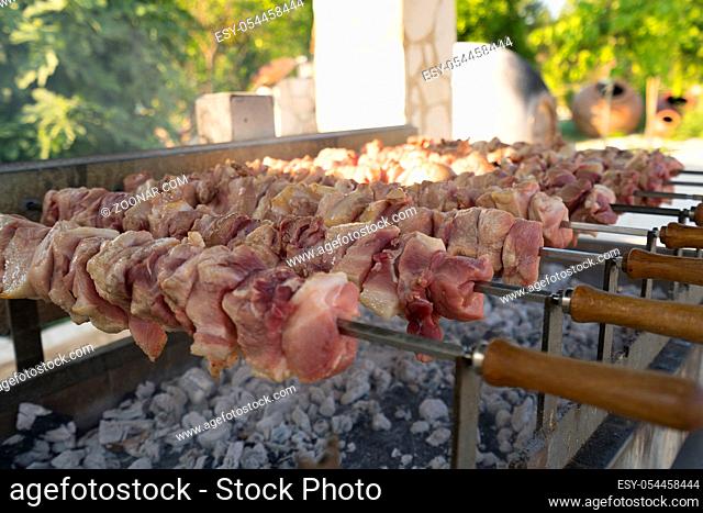Shashlik being fried out-of-doors in a park on Cyprus island on summer sunny day close up shot