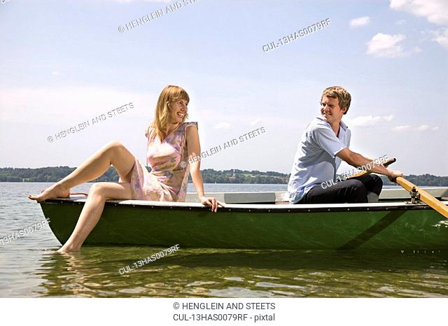 man and woman rowing boat on lake