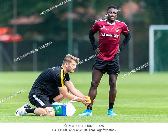 14 August 2019, Saxony, Dresden: Soccer: 2nd Bundesliga, Training, SG Dynamo Dresden. Dynamo's physiotherapist Julian Binder (l) provides Moussa Kone with care...