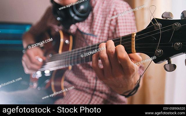 Male musician plays the guitar, hands close up, art concept
