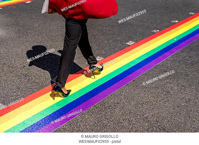 Legs of businesswoman crossing the street on LGBT stripes, London, UK