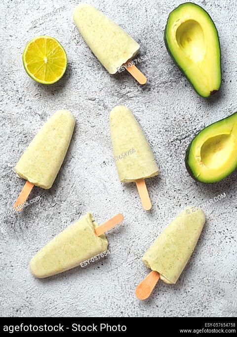 Homemade raw vegan avocado lime popsicle. Sugar-free, non-dairy green ice cream on gray background. Top view. Ideas and recipes for healthy snack