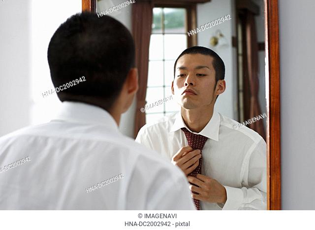 Man Adjusting His Tie