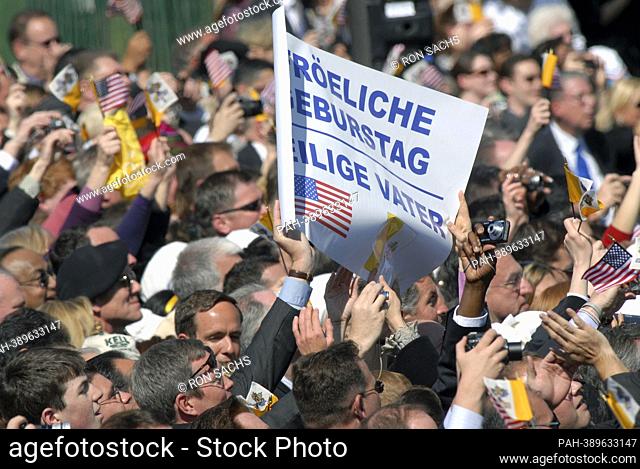 A sign held up during the impromptu singing of ""Happy Birthday for Pope Benedict XVI during the early part of his arrival at the White House in Washington, D