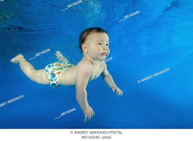 little boy learns to swim underwater in the pool