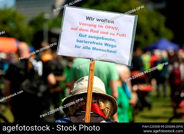 08 May 2022, North Rhine-Westphalia, Duesseldorf: A demonstrator holds up a poster with the inscription: ""We want priority in public transport on the bike and...