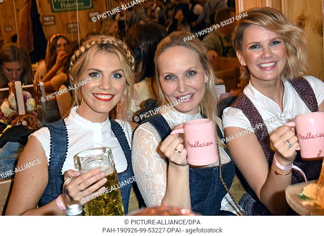 26 September 2019, Bavaria, Munich: The presenters Viviane Geppert (l-r), Franca Lehfeldt and the model Monica Ivancan celebrate at the ""Madlwiesn"" in the...