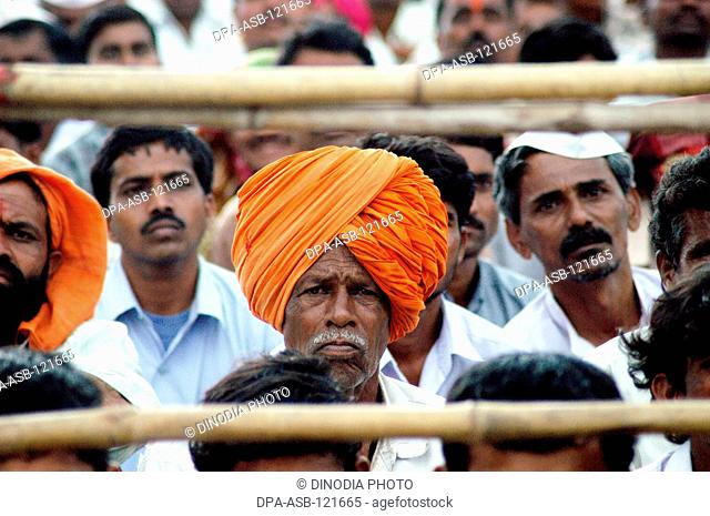 A villager wearing a saffron colored turban attends a election public rally addressed by BJP leader Pramod Mahajan at Ahmednagar , Maharashtra , India