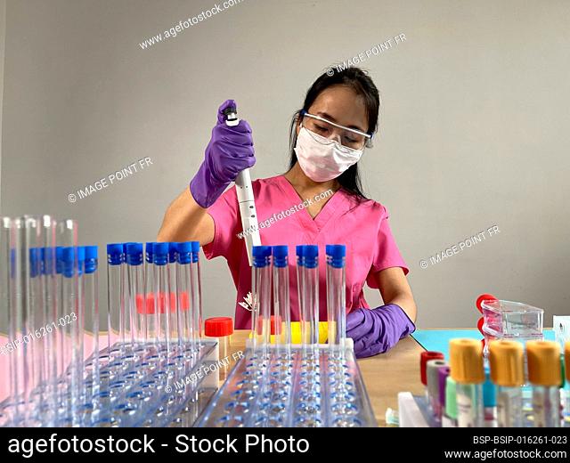 Woman injecting a substance into a tube using a multichannel pipette