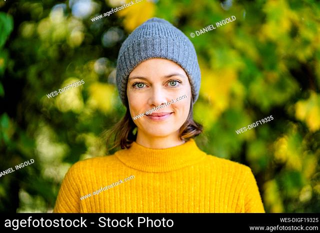 Smiling woman standing with knit hat