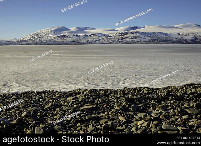 Snowy landscape in spring time with mountains in background, frozen lake Torneträsk, Kiruna county, Swedish Lapland, Sweden