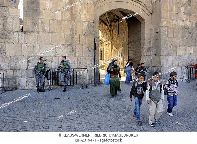 Israeli guards and Palestinian children with toy guns coming out from the Arab Quarter through the Lion Gate into the Old City of Jerusalem, Israel, Middle East