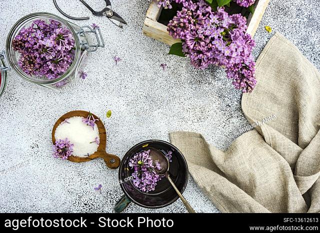 Bowl with sugard and lilac flower on rustic background