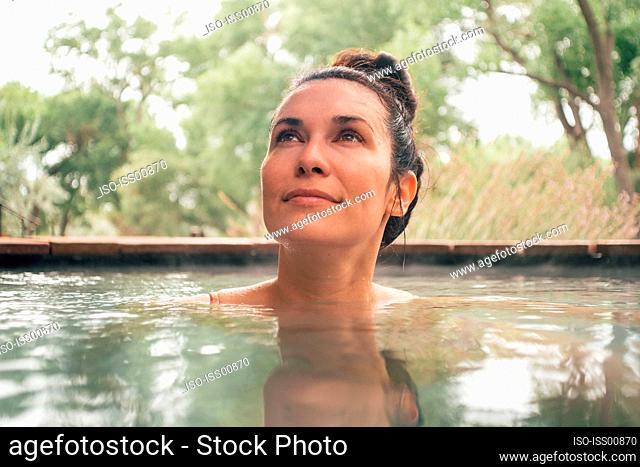 Woman relaxing in swimming pool in spa resort