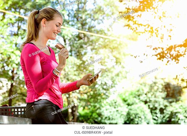 Young woman using smartphone in park