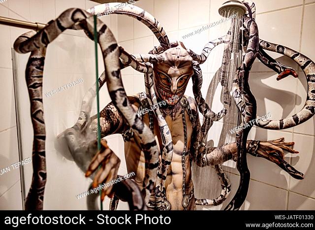 Man taking shower in spooky Medusa costume