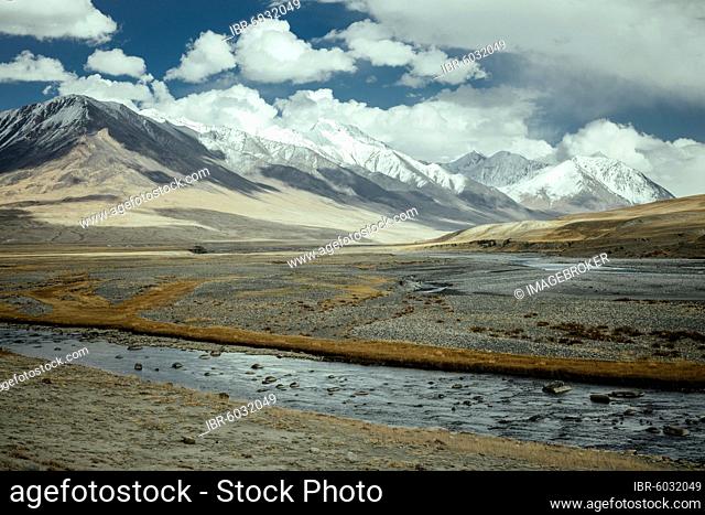 The Wachandarja River meanders through a wide gravel bed on a plateau of the Wakhan Corridor near Bozai Gumbaz, in the background the snow-covered peaks of the...