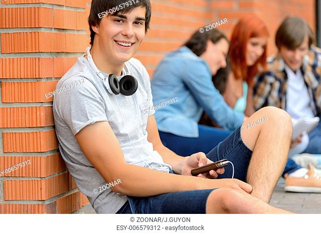 College student boy sitting ground with friends