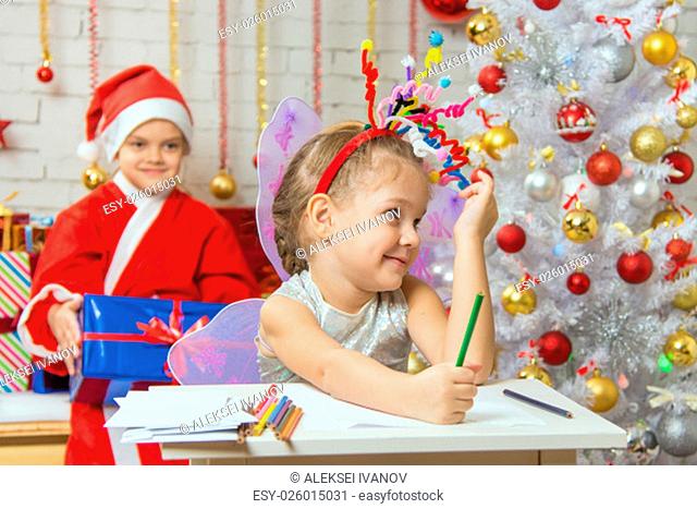 Girl sits at a table with a pencil and a piece of paper with a fireworks display on the head, santa claus her ready to give her a gift