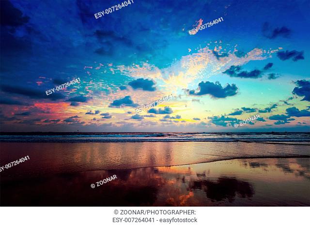Vintage retro hipster style travel image of tropical vacation holidays concept - sunset on idyllic beach. Baga
