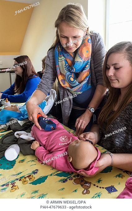 Social worker Julia Wiesend (C )shows some teenage girls how to swaddle a baby during an internship for parents to prevent young people to get children in...