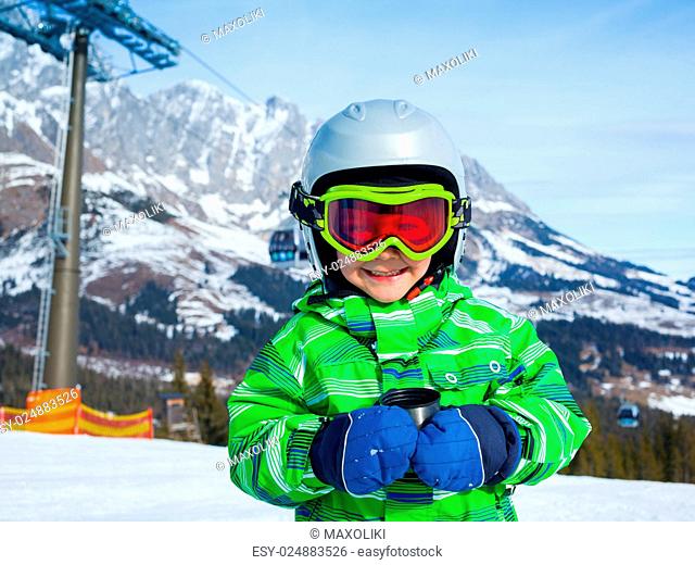Ski, skier, winter. Lovely small boy has a fun on ski - resting and drinking tea from a thermos