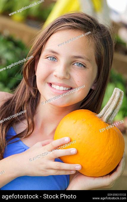 Pretty Young Girl Having Fun with the Pumpkins at the Market