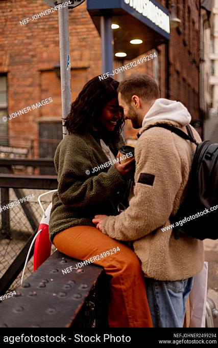 Young couple kissing near canal in town