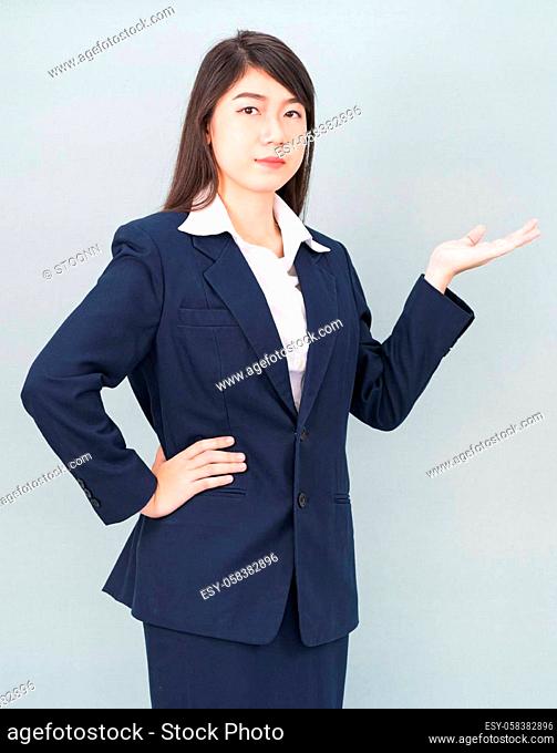 Asian woman in suit open hand palm gestures with empty space isolated on gray background