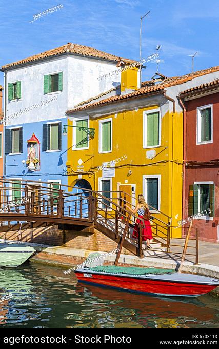 Young woman in front of colorful houses, colorful house facades, Burano Island, Venice, Veneto, Italy, Europe