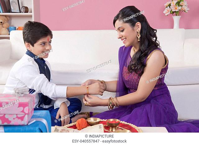 Sister tying rakhi on her brother wrist