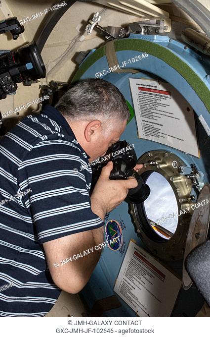 Expedition 36 Flight Engineer Fyodor Yurchikhin with Russia's Federal Space Agency (Roscosmos) takes pictures of a highly anticipated event from a window in the...