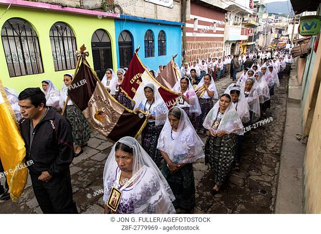 Catholic procession of the Virgin of Carmen in San Pedro la Laguna, Guatemala. Women in traditional Mayan dress with white mantillas over their heads