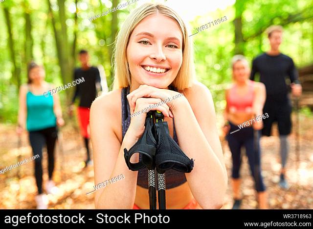 Lächelnde Frau mit Freunden im Nordic Walking Workshop in der Natur im Sommer