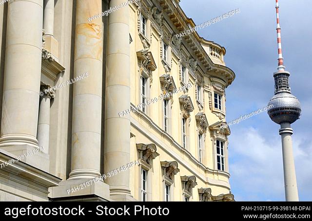 15 July 2021, Berlin: The TV tower at Alexanderplatz rises next to the façade of the Humboldt Forum. The rebuilt Berlin City Palace opens on 20 July with...
