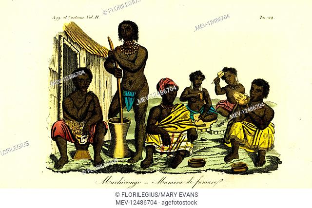 Muchicongo men and many wives outside a hut, Angola. The men drink and smoke cachimbo pipes, while the women pound corn to make the local drink of oualo