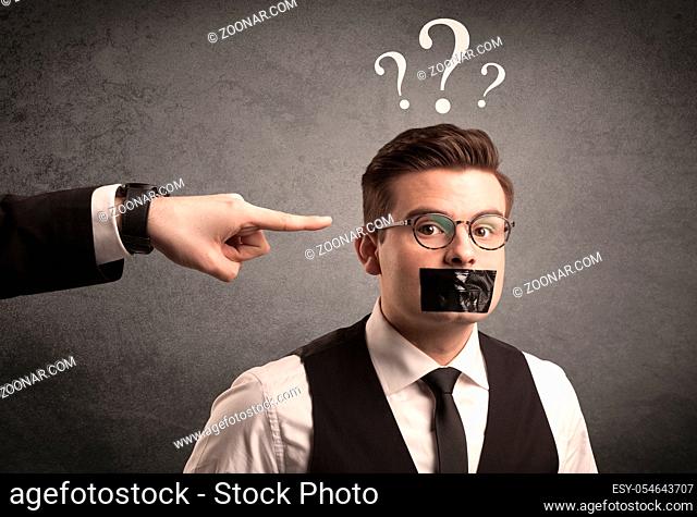 Caucasian business hand pointing at scared employee with big white question marks above his head
