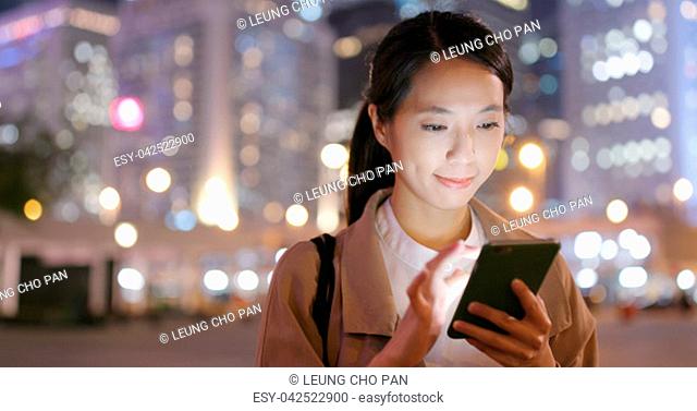 Business woman use of smart phone in city at night